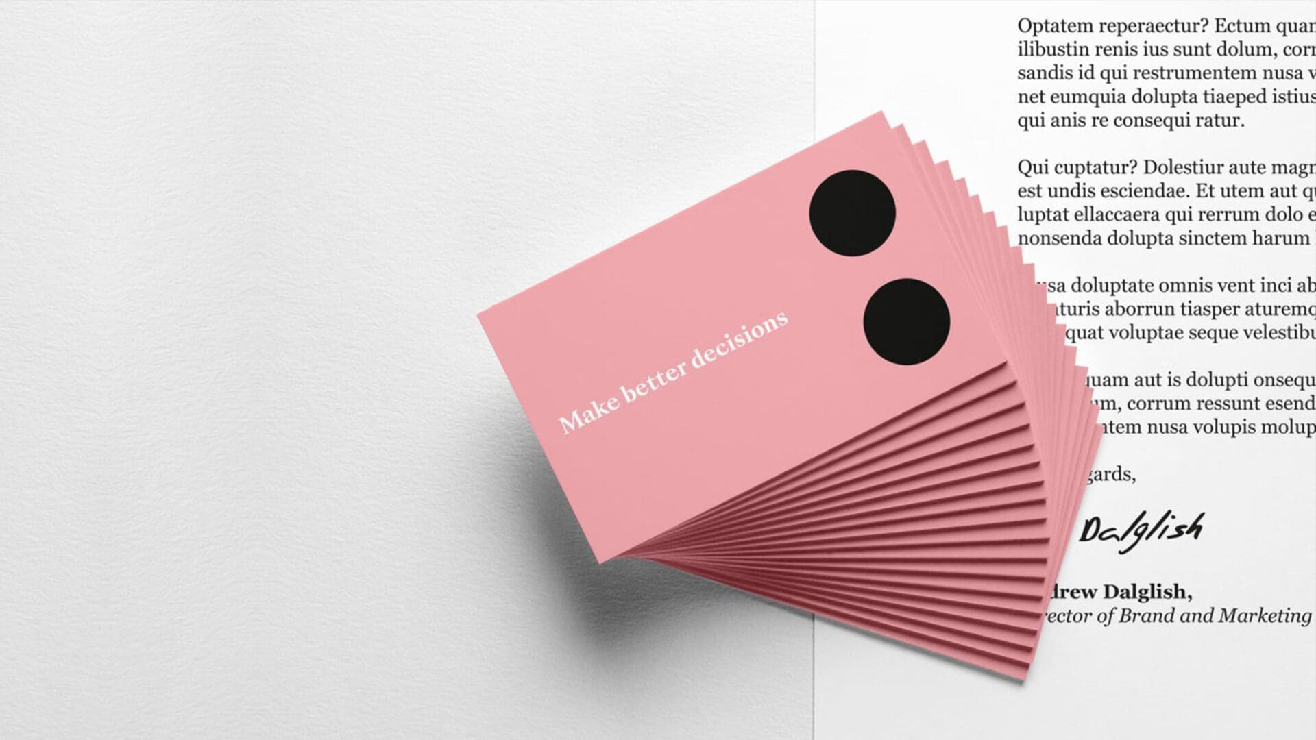 Stack of pink business cards reading "Make better decisions" beside a document.