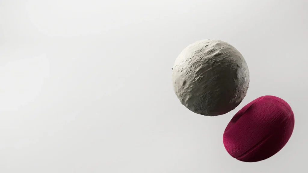 A textured gray sphere floats above a maroon oval object against a white background.